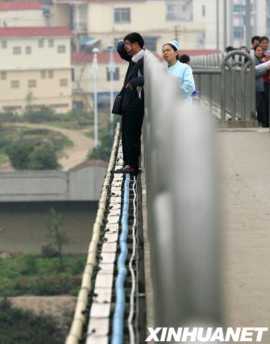 3月8日，在广西南宁市白沙大桥，扮成护士的女警察（左二）正在劝说欲从距水面约30米高的桥上跳下的男子。当日，一名男子站在广西南宁市白沙大桥栏杆外面欲寻短见。警方接到市民报警后，派遣一名女警察扮成护士，接近男子开展劝说工作。经过近一个小时的劝说，欲寻短见的男子被成功解救。 
