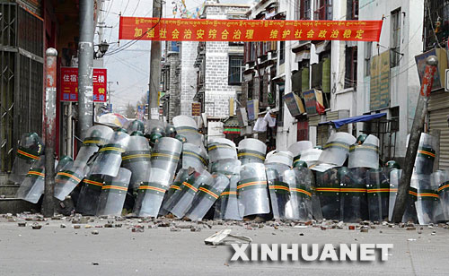 这张路透社播发的照片显示，3月14日，在拉萨市，处置打砸抢烧事件的武警用盾牌抵挡不法分子投掷的石块。     这是一起骇人听闻的严重暴力犯罪事件。     3月14日，一群不法分子在西藏自治区首府拉萨市区的主要路段实施打砸抢烧，焚烧过往车辆，追打过路群众，冲击商场、电信营业网点和政府机关，给当地人民群众生命财产造成重大损失，使当地的社会秩序受到了严重破坏。事后查明，这天，不法分子纵火300余处，拉萨908户商铺、7所学校、120间民房、5座医院受损，砸毁金融网点10个，至少20处建筑物被烧成废墟，84辆汽车被毁。有18名无辜群众被烧死或砍死，受伤群众达382人，其中重伤58人。拉萨市直接财产损失达24468.789万元。 这是一场反对分裂，维护祖国统一和民族团结的斗争。 为了尽快恢复正常的社会秩序，西藏自治区党委、政府组织公安、武警，对在拉萨街头十分猖狂地进行打砸抢烧的不法分子依法打击，迅速平息了事态，维护了社会稳定，维护了国家法制，维护了西藏各族群众的根本利益。     根据目前掌握的情况，这起严重的暴力犯罪事件是由达赖集团有组织、有预谋、精心策划煽动的，是由境内外“藏独”分裂势力相互勾结制造的。