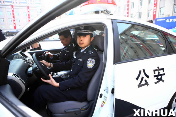 3月31日，警察准备驾驶混合动力环保车离开交车现场。 当日，北京市公安局获赠价值600万元的16辆警用车辆。这是油电混合动力环保车首次装备北京警方。 新华社记者陈建力摄 