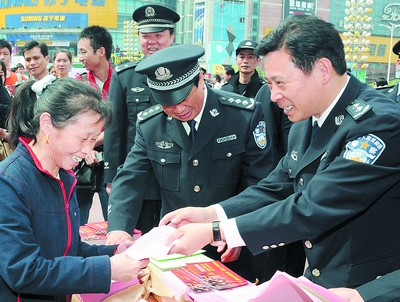 昨日,在黄兴南路步行商业街中心广场,民警向市民分发资料,传授安全防范知识。王文虎摄