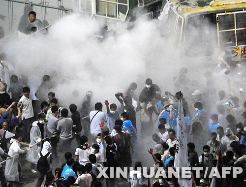 6月22日，韩国警察在首尔用灭火器驱散示威人群。韩国与美国在6月21日达成共识，美国将仅向韩国出口牛龄在30个月以下的牛肉。韩国官员希望，持续多日的牛肉风波及其引发的一系列政治危机能够因此告一段落，但截至22日民众的抗议活动仍在继续。抗议者称，补充协议仍未能从根本上杜绝牛肉安全隐患。     新华社/法新 