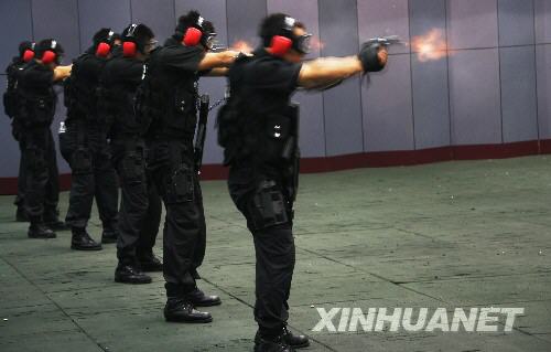 7月11日，“蓝剑突击队”队员进行射击训练。当日，北京市公安局特警总队“蓝剑突击队”在北京人民警察学院训练馆进行战术对抗和射击训练。这支由120名特警精英（包括10名女特警）组成的突击队将在北京奥运会期间承担最艰巨的反恐处突任务。