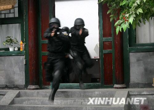  7月11日，“蓝剑突击队”队员进行战术对抗训练。当日，北京市公安局特警总队“蓝剑突击队”在北京人民警察学院训练馆进行战术对抗和射击训练。这支由120名特警精英（包括10名女特警）组成的突击队将在北京奥运会期间承担最艰巨的反恐处突任务。 