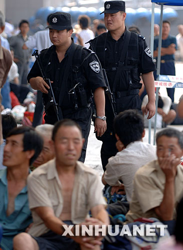 7月22日,两名特警在北京西站广场执勤。近日,北京铁路警方加强了北京各个火车站的安全保卫工作,凡是进入火车站的人员都要接受安检。 新华社记者 公磊 摄
