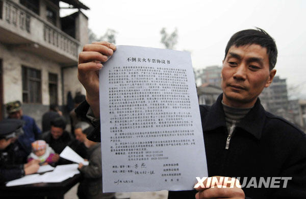 1月12日,一名四川省达州市达县河市镇锁口村的村民在展示他与铁路公安机关签订的“不倒卖火车票协议书”。