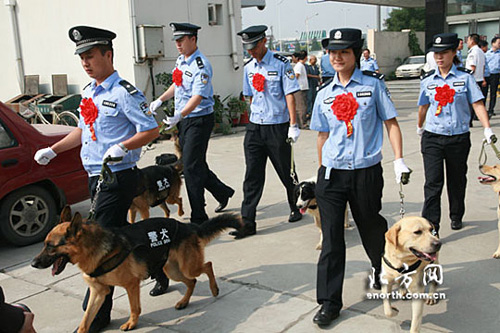 图为警犬与主人们在一起。