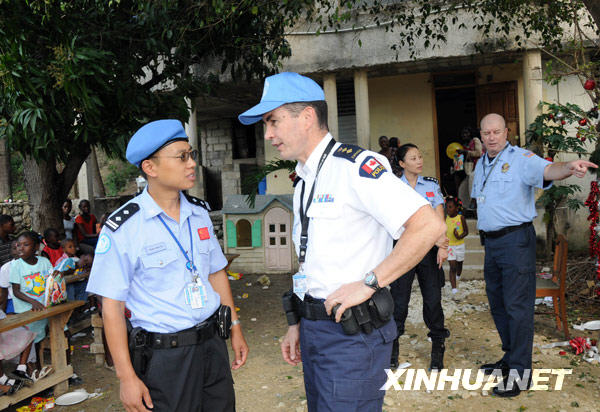 这是赵化宇（前左）在海地太子港的一所孤儿院与联合国驻海地稳定特派团（联海团）代理总警监道格拉斯·科斯塔交谈的资料照片。
