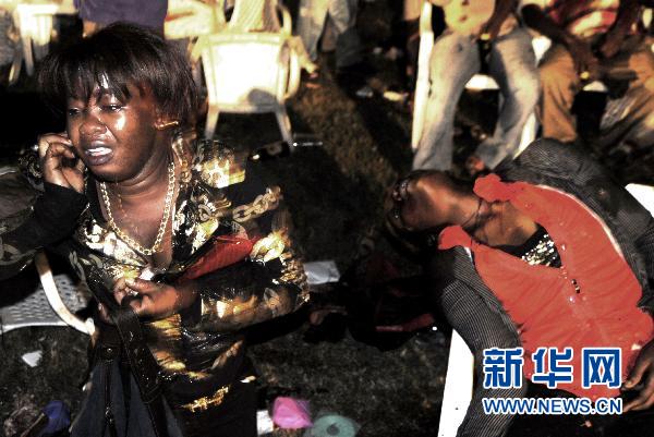     7月11日，在乌干达首都坎帕拉的一家埃塞俄比亚餐馆爆炸现场，一名妇女坐在一名遇难者旁。 据乌干达国有报纸《新景报》网站12日报道，11日深夜发生在首都坎帕拉的两起爆炸事件已造成至少23人死亡。 新华社/美联