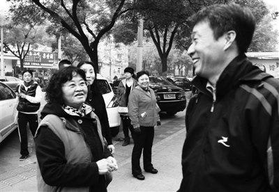 10月26日,治安志愿者们见到张惠领，停下脚步打招呼。
