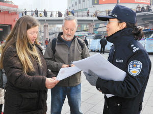 公安雁塔分局在小寨赛格广场开展“110”宣传活动。图为民警向国际友人发放宣传单