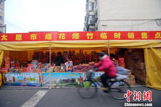 资料图：民众从烟花爆竹销售点经过。张云 摄