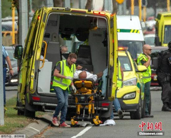 图为一名受伤人员被送入救护车。