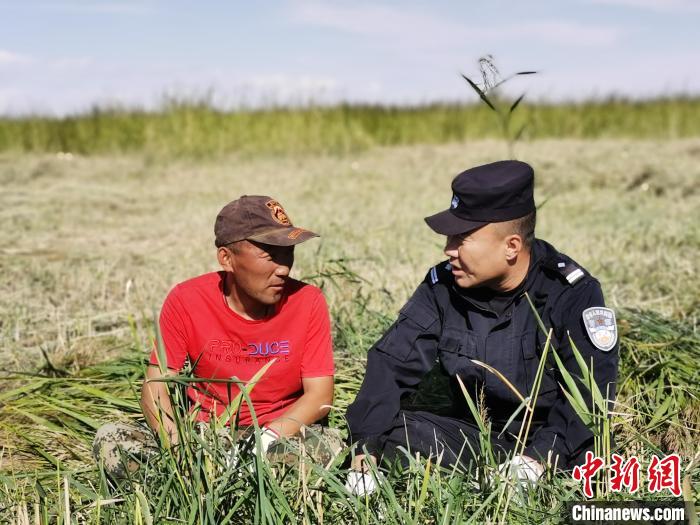 图为阿古达木与牧民交谈。　牛鑫 摄