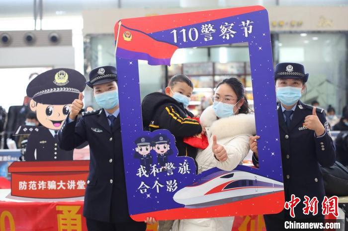 民警与旅客互动合影，开展高铁出行安全知识普及。　泱波 摄