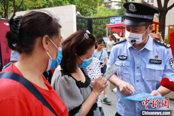 图为民警向市民宣传国家反诈APP。　乐雪 摄