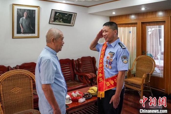 杨仁德(右一)第一时间向“师傅”全国公安系统一级英模陈善珉报喜。　福州铁路公安处 供图