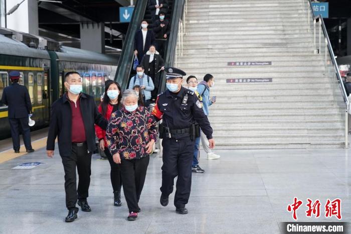 图为杨仁德(右一)服务旅客群众。　福州铁路公安处 供图