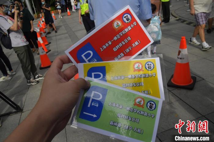 交警分发高、中、低年级学生车辆接送分别使用红黄绿“三色”停车卡规范错峰停车时间。　上海警方供图