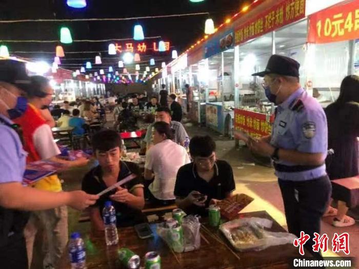 治安提示送进夜市餐饮摊点。　王亮 摄