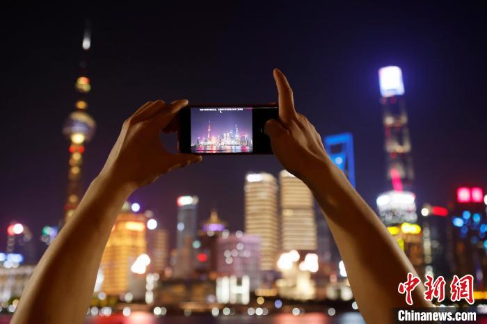 游客在外滩滨江步道上用手机拍摄黄浦江两岸夜景。　殷立勤 摄