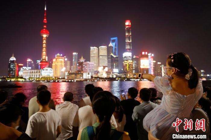 游客带着孩子在外滩滨江步道上欣赏黄浦江两岸夜景。　殷立勤 摄