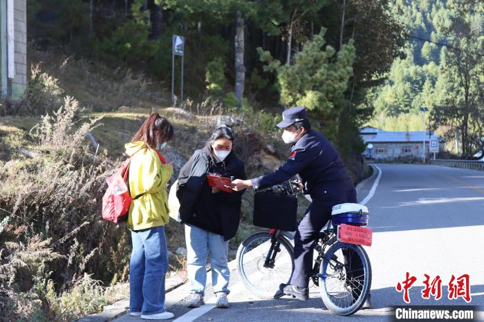 图为骑行宣讲队民警向辖区群众发放边境管理和法治宣传资料。　关申建 摄