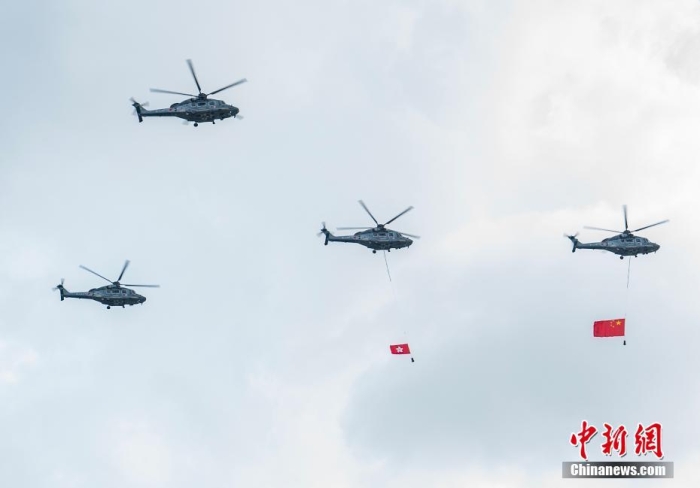 7月1日，庆祝香港回归祖国26周年升旗仪式在金紫荆广场举行。图为直升机护卫中国国旗和香港特别行政区区旗通过广场上空。<a target='_blank' href='/'>中新社</a>记者 侯宇 摄