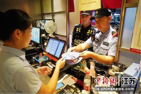 南京玄武公安分局民警向辖区商户发放反诈宣传扇。南京警方供图