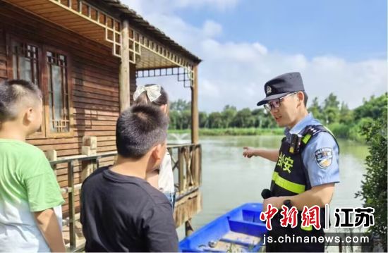南京六合公安分局民警向孩子们宣传夏季防溺水注意事项，并提醒家长不要让孩子脱离自己视线。南京警方供图