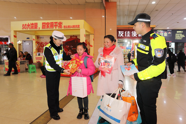 交巡警在车站给旅客赠送小礼品。南岸区公安分局供图