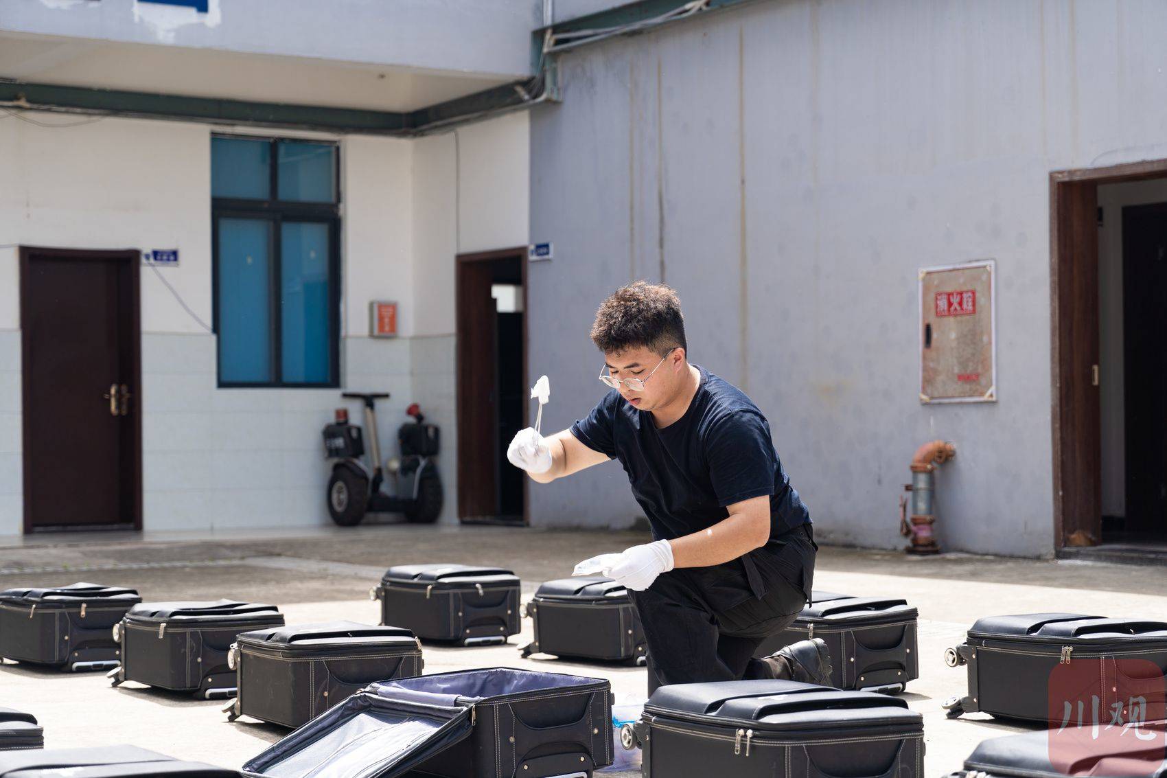 助训员将沾有毒品气味的沾染物放入箱包中。资阳市公安局供图
