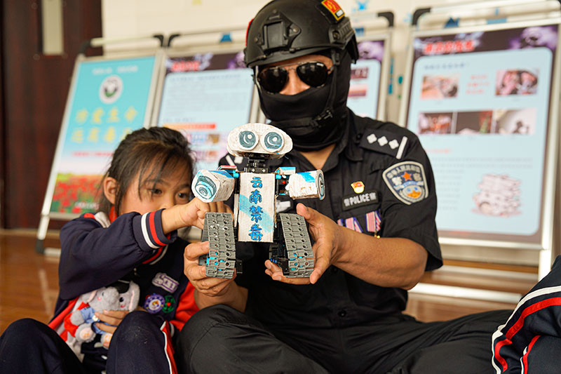 孩子向缉毒警解说”扫毒机器人“。楚雄州公安局供图