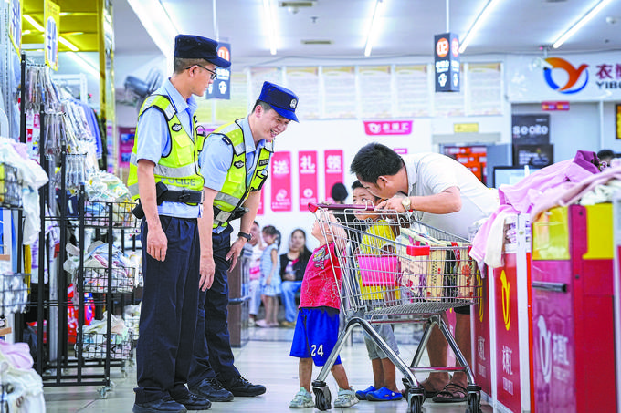 ?8月27日，贵州省凯里市公安局组织开展拉网式大排查，民警在超市和群众交流。周国辉摄