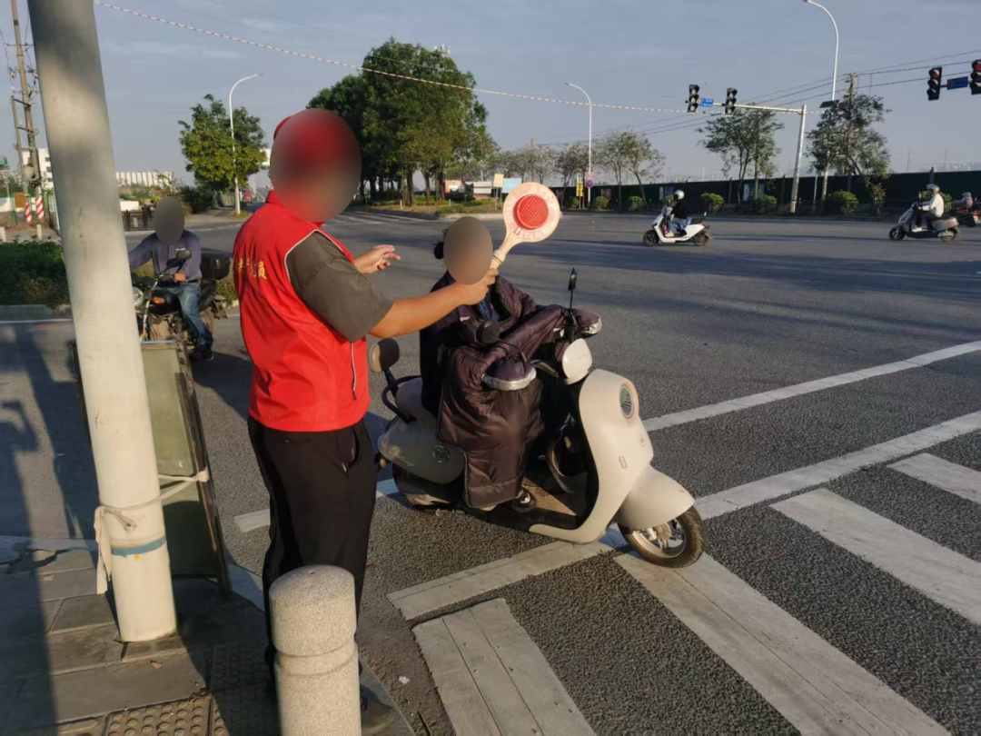 实施轻微交通违法行为的电动自行车驾驶人以志愿者身份劝导不文明交通违法行为。广州交警供图